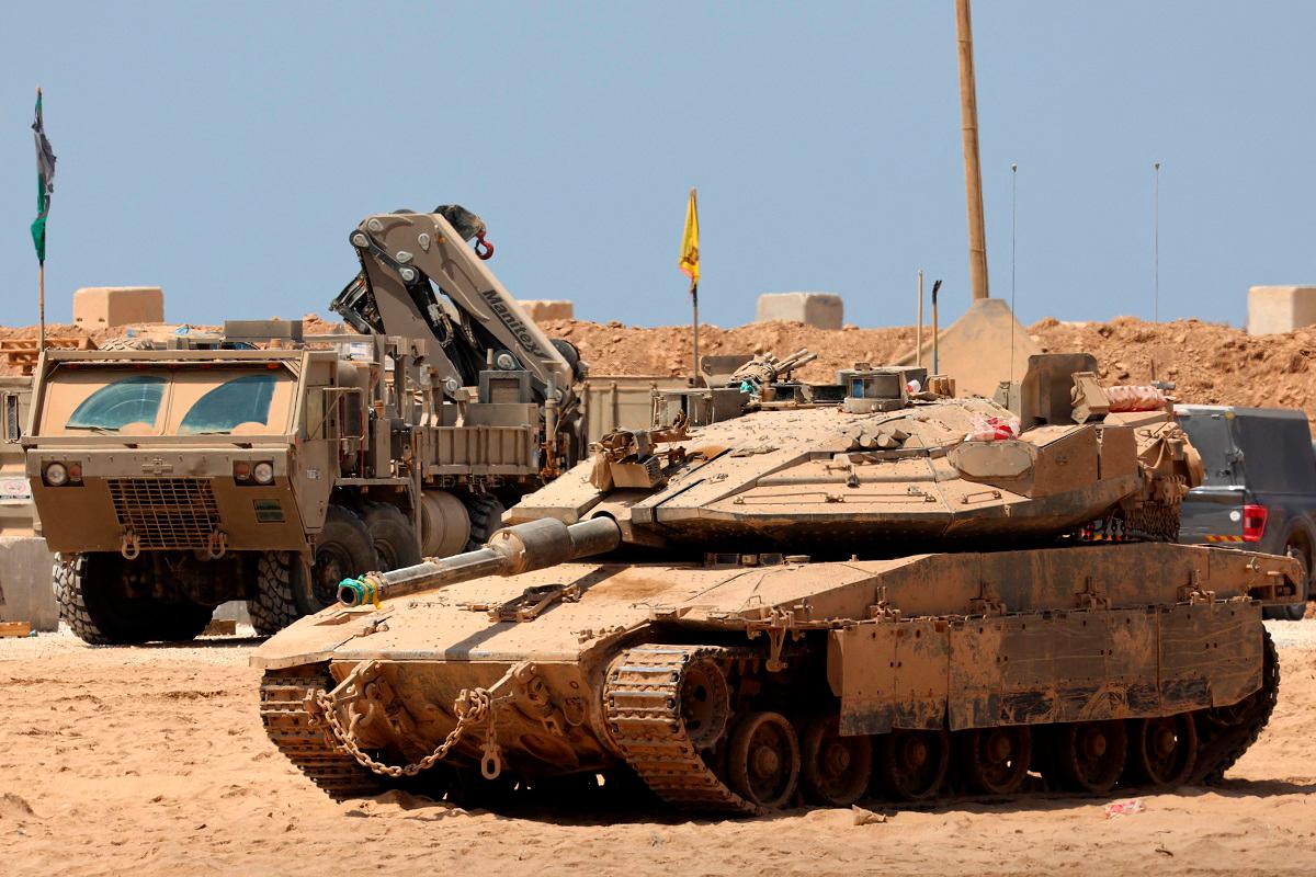Israeli military vehicles are positioned along the border with the Gaza Strip on August 21, 2025. Israel hammered Gaza City and its outskirts overnight, residents said on August 20, as the military announced it had taken initial steps in its push to capture Hamas’s last major stronghold. - Jack GUEZ / AFP