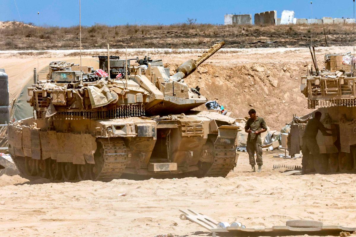 Israeli army main battle tanks are positioned near the border with the Gaza Strip in southern Israel on August 27, 2025. Israeli military pressed operations around Gaza City on August 27, as President Donald Trump prepared to host a White House meeting on post-war plans for the shattered Palestinian territory. (Photo by Jack GUEZ / AFP)