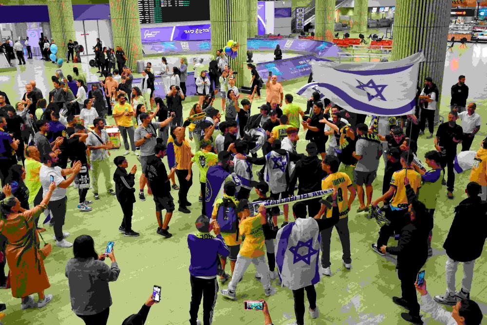 Maccabi Tel-Aviv fans carry flags as they wait for the arrival of their friends and family members from Amsterdam, at the Ben Gurion International Airport on the outskirts of Tel Aviv. AFPPIX