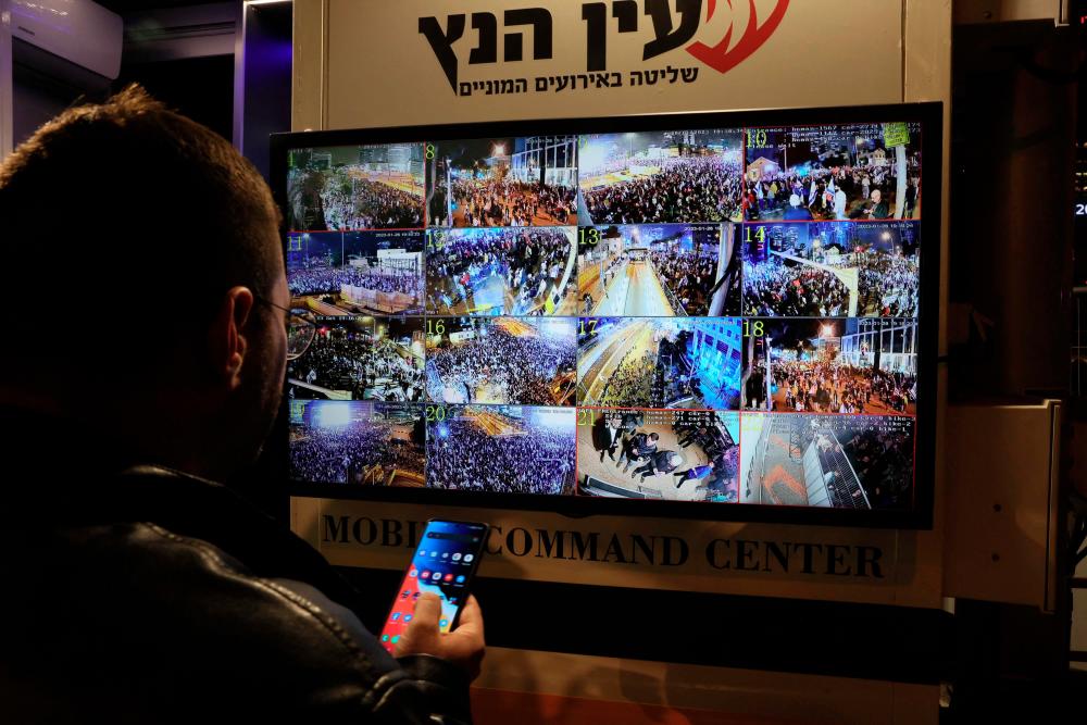 A man stands in front of a monitor showing surveillance camera feeds in Tel Aviv on January 28, 2023 during a protest against controversial government plans to give lawmakers more control of the judicial system. AFPPIX