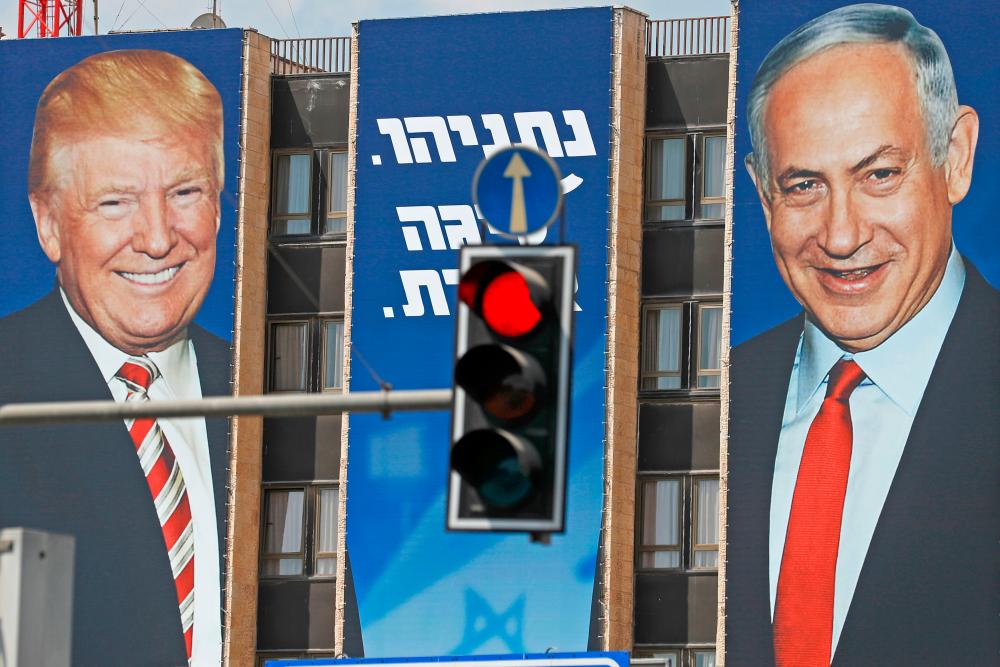 This picture taken on Sept 14, 2019 shows an Israeli election banner depicting US President Donald Trump (L) and Likud chairman and Prime Minister Benjamin Netanyahu hanging on the facade of a building in Jerusalem. — AFP