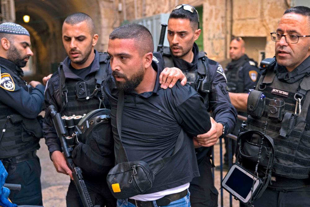 Israeli policemen detain a Palestinian man in the old city of Jerusalem on October 12, 2022 as the area is under high alert during the Jewish pilgrimage holiday of Sukkot, or the Feast of the Tabernacles. AFPPIX