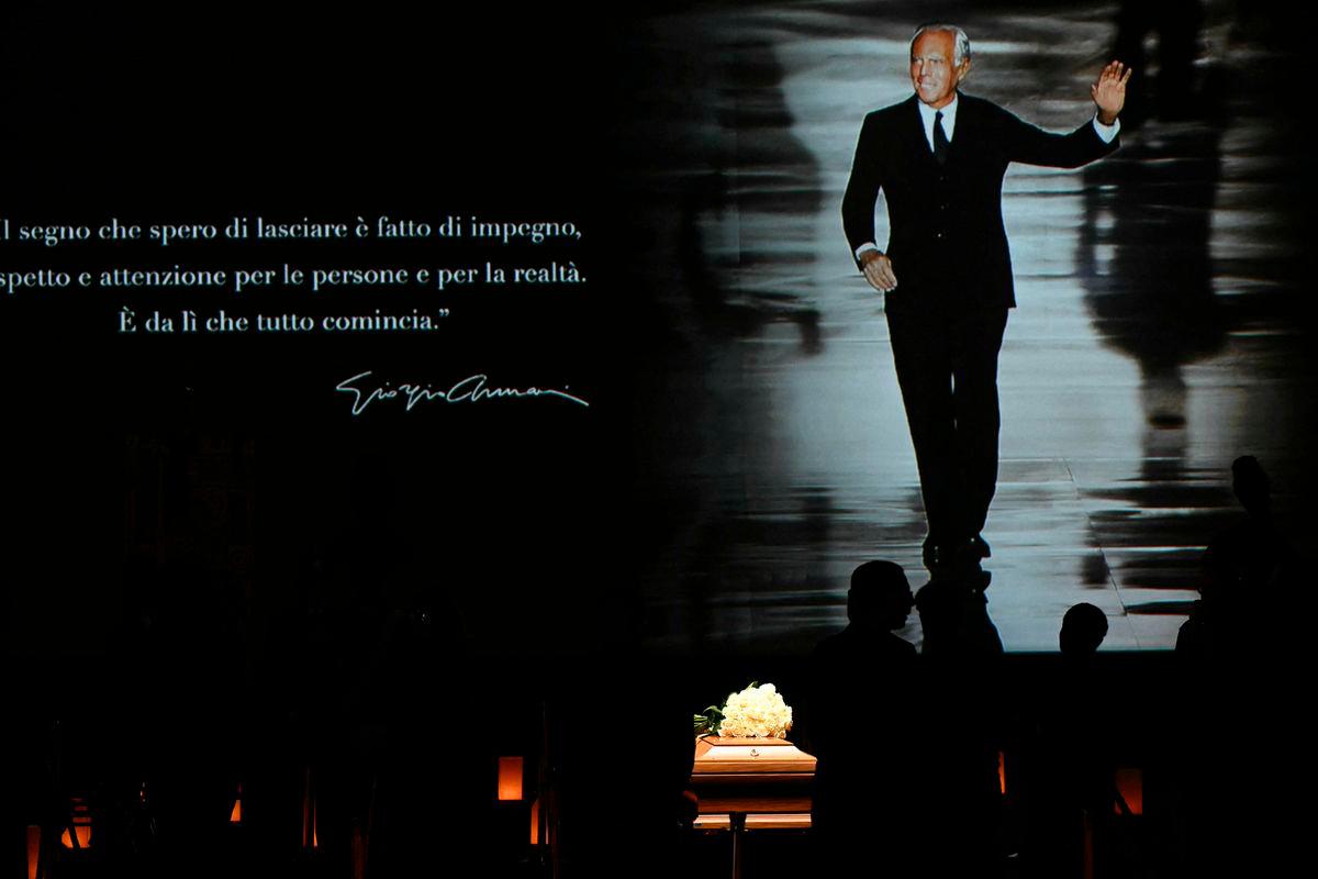 People queue to see the coffin of late Italian fashion designer Giorgio Armani lying-in state for two days at the Armani Theatre in Milan as a picture of him is seen on a screen, on September 6, 2025. The screen reads “The mark I hope to leave is one of commitment, respect, and genuine care for people and for reality. “That’s where everything truly begins.” Giorgio Armani died on September 4, 2025 at 91. (Photo by Stefano RELLANDINI / AFP)
