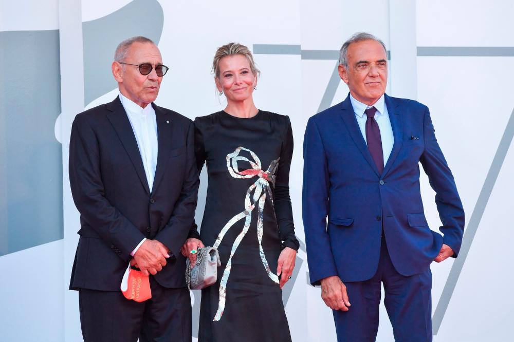Director of the Venice Film festival, Alberto Barbera (R) greets Russian director Andrei Konchalovsky and Russian actress Julia Vysotskaya as they arrive for the screening of the film “Dorogie Tovarischi! (Dear Comrades!)” presented in competition on the sixth day of the 77th Venice Film Festival, on September 7, 2020 at Venice Lido, during the COVID-19 infection, caused by the novel coronavirus. / AFP / Tiziana FABI
