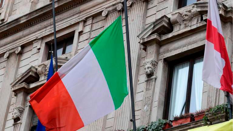 The Italian flag flies at half-mast on the city hall of Milan at noon on March 31, as flags are being flown at half-mast in cities across Italy to commemorate the victims of the virus, during the country’s lockdown aimed at curbing the spread of the Covid-19 infection, caused by the novel coronavirus. - AFP