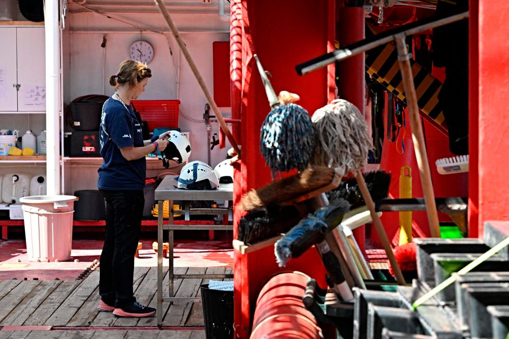 A member of SOS Mediterranee NGO, maintains the equipment on the deck of migrant rescue ship Ocean Viking, operated by SOS Mediterranee NGO, as it is docked at the port of Civitacecchia on July 14, 2023, after the authorities ordered the ship held “for an indefinite period” in port/AFPPix