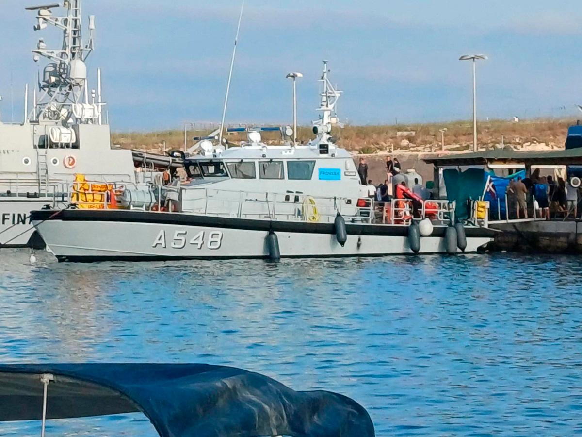 Migrants disembark from the boat that rescued them after their ship sank off the coast of Italy’s Lampedusa island in the harbour of Italian island of Lampedusa on August 14, 2025. - STR / ANSA / AFP
