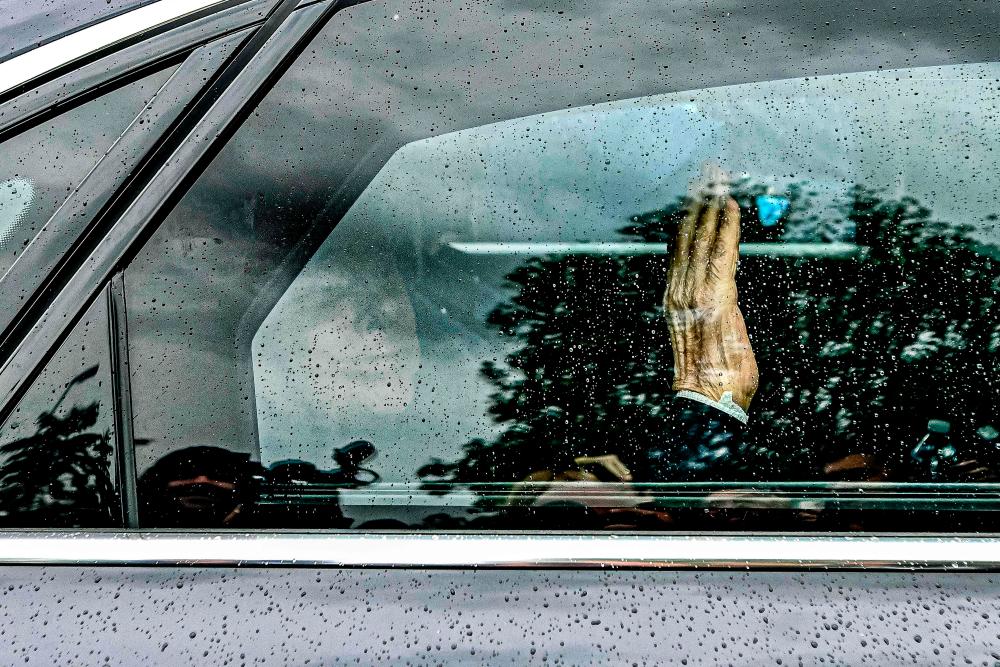 Former Italian premier Silvio Berlusconi waves from inside his car as he leaves on May 19, 2023 the San Raffaele hospital in Milan after being discharged. AFPPIX