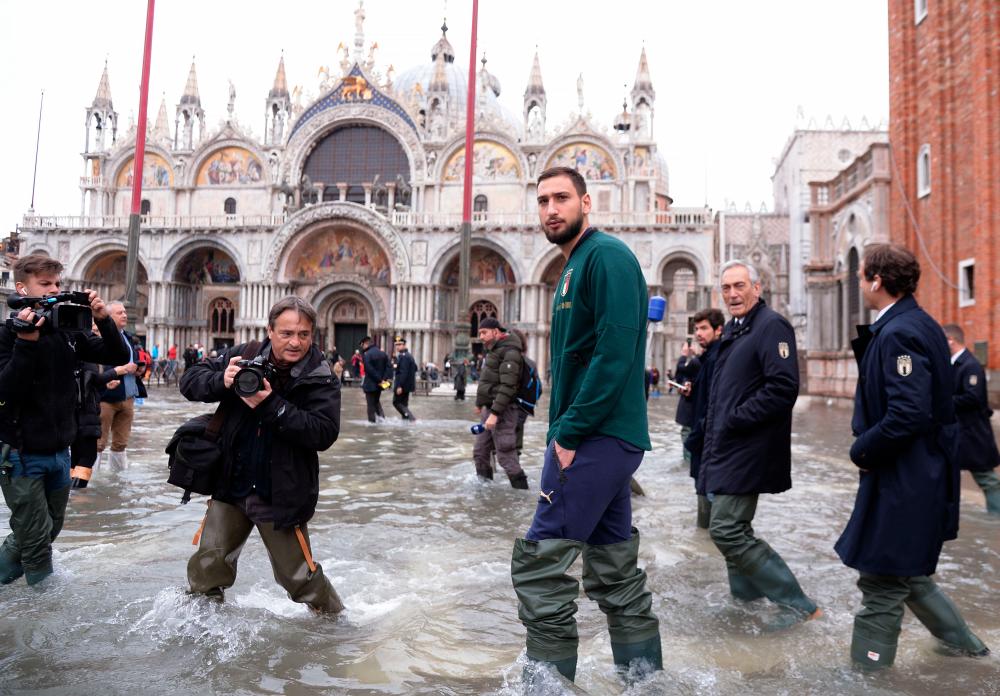 AC Milan's goalkeeper Gianluigi Donnarumma walks in St Mark square on November 16, 2019 in Venice, three days after the city suffered the highest tide in 50 years. - AFP