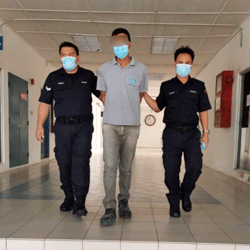 The suspect escorted by the police to be remanded for seven days. -The Borneo Post