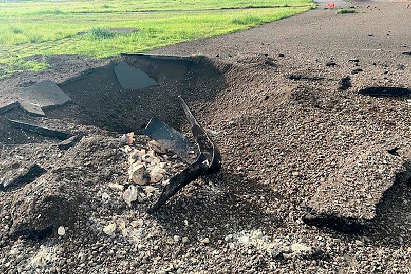 This recent handout photo released to AFP by the Miyazaki Airport Office of the Ministry of Land, Infrastructure, Transport and Tourism on October 4, 2024 shows debris on the edge of the airport tarmac after an unexploded World War II US bomb blew up less than a minute after a passenger jet taxied past on October 2 at Miyazaki airport in southern Kyushu island. A total of 55 flights were cancelled on October 2, according to All Nippon Airways and Japan Airlines, affecting more than 3,400 passengers, with flights resuming the next day. - AFP PHOTO / Miyazaki Airport Office of the Ministry of Land, Infrastructure, Transport and Tourism