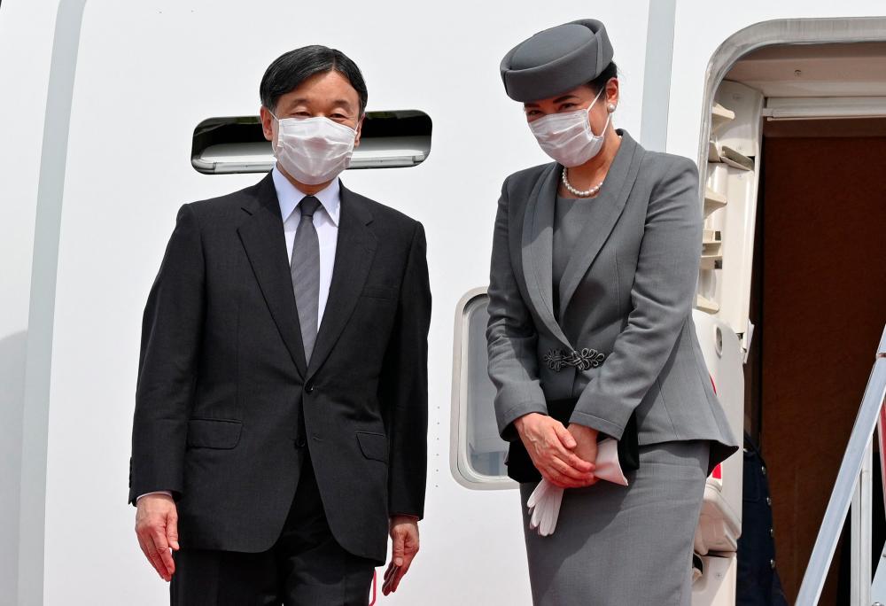 Japanese Emperor Naruhito (L) and Empress Masako greet well wishers before their departure for London to attend the state funeral of Britain Queen Elizabeth II, at Haneda airport in Tokyo on September 17, 2022. - AFPPIX