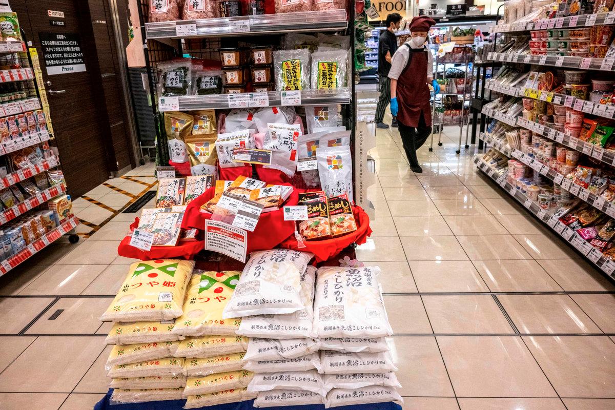 Bags of rice (C) are displayed for sale at a supermarket in Tokyo on May 23, 2025. Japan’s core inflation rate accelerated in April to 3.5 percent as rice prices almost doubled year-on-year, official data showed on May 23. - AFPpix
