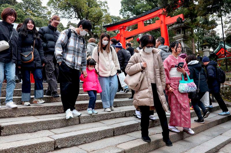 Tourists walk down steps during a visit to Fushimi Inari Shrine in the city of Kyoto on January 13, 2025. - AFPPIX