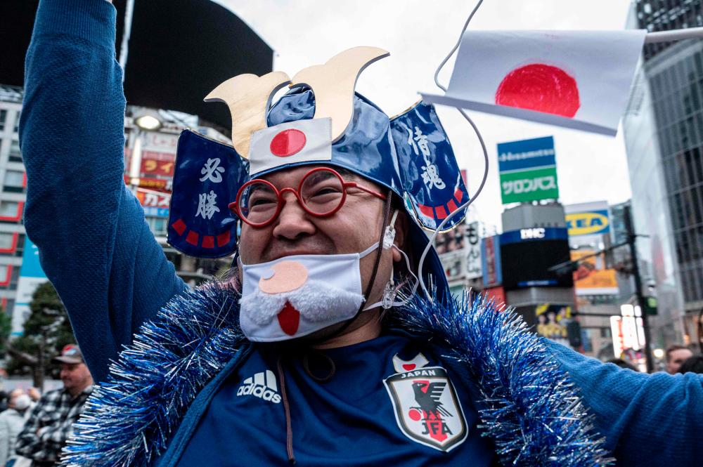 Fans celebrate after Japan’s victory over Spain in the Qatar 2022 World Cup Group E football match to advance to the second round, at the Shibuya Crossing area in Tokyo, Japan, on December 2, 2022. AFPPIX