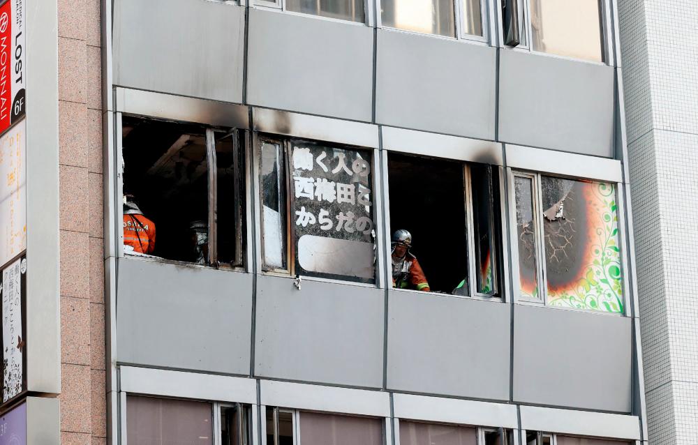 Firefighters work at the scene, where twenty-seven people were feared dead after a blaze at a building in Osaka, on December 17, 2021. AFPPIX