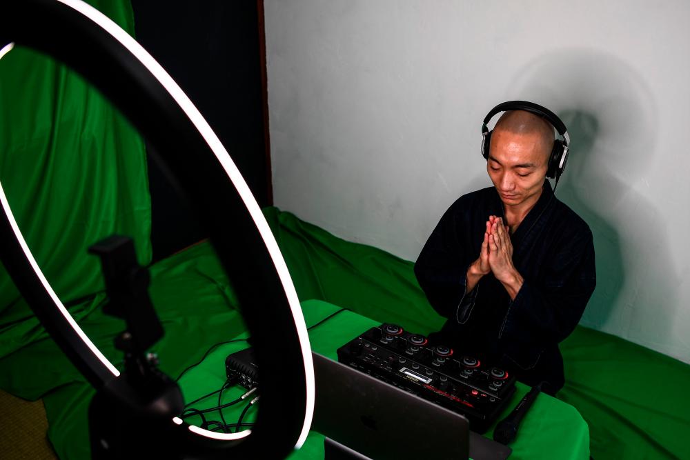 $!This photo taken on June 26, 2020 shows Yogetse Akasaka, a Buddhist monk and beatbox musician, presenting a live stream beatboxing performance at his home in Tokyo. / AFP / CHARLY TRIBALLEAU /