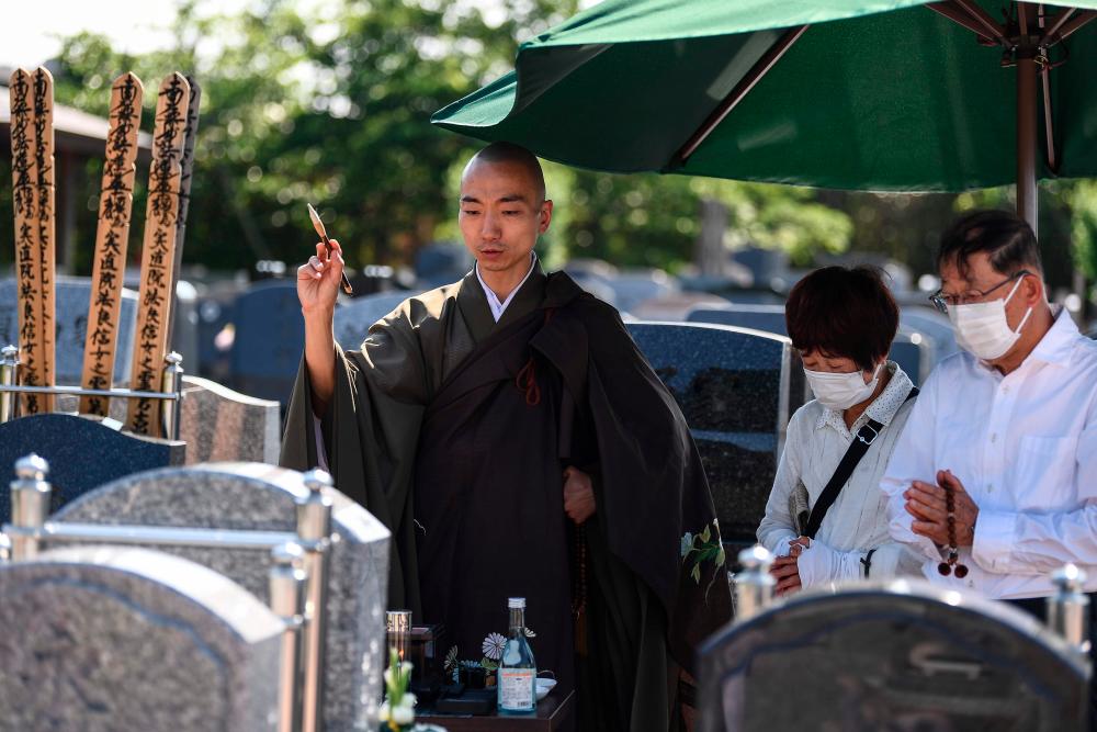 $!This photo taken on June 16, 2020 shows Yogetse Akasaka (L), a Buddhist monk and beatbox musician, taking part in a ceremony to move deceased ashes to a new cemetery, in Shimoshizu, Chiba prefecture. / AFP / CHARLY TRIBALLEAU /