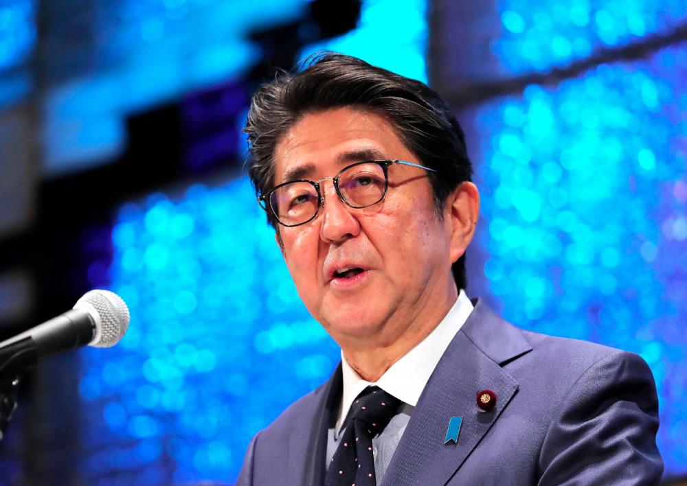 Japan's Prime Minister Shinzo Abe delivers a speech during a lecture in Tokyo on Dec 13. — AFP