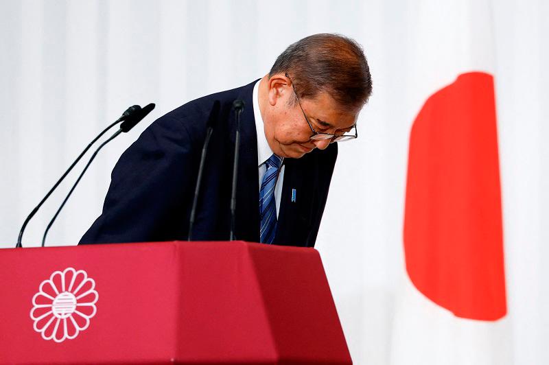 Shigeru Ishiba, Japan's Prime Minister and leader of the ruling Liberal Democratic Party (LDP), bows to LDP lawmakers onstage after a press conference at the party's headquarters in Tokyo on October 28, 2024. Ishiba said on October 28 he will stay in office despite his party losing its majority, saying he would not create a political vacuum. - Kim Kyung-Hoon / POOL / AFP