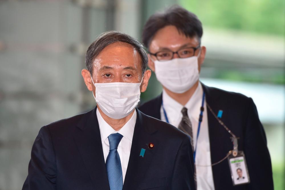 Japan’s new Prime Minister Yoshihide Suga (L) arrives at his office in Tokyo on September 16, 2020. — AFP