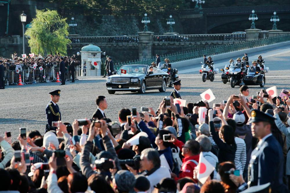 People cheer as the motorcade of Japan’s Emperor Naruhito and Empress Masako leaves the Imperial Palace during a royal parade in Tokyo on November 10, 2019. - AFP