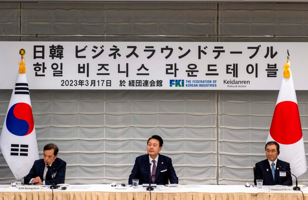 South Korea’s President Yoon Suk Yeol (C) joins Masakazu Tokura (R), chairman of Keidanen, the Japan Business Federation, and Kim Byong-joon (L), acting chairman of the Federation of Korean Industries, as they attend a Japan-Korea Business Roundtable meeting in Tokyo on March 17, 2023. AFPPIX