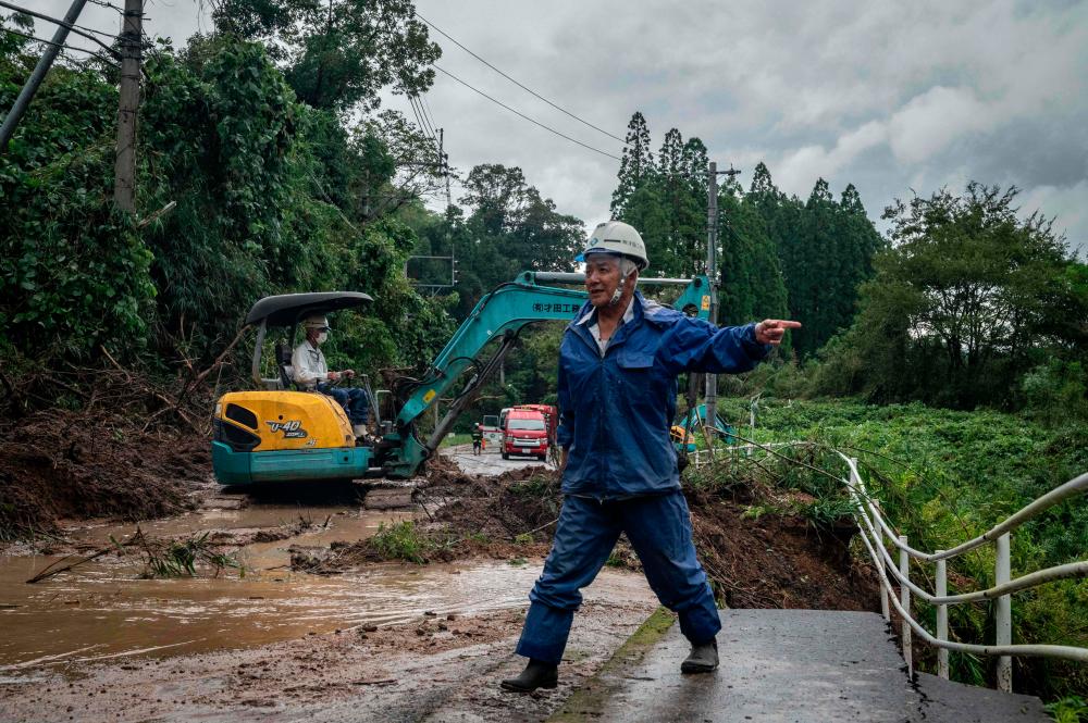 Pekerja membersihkan serpihan dan lumpur di tapak tanah runtuh yang disebabkan oleh Taufan Nanmadol di Mimata, wilayah Miyazaki pada 19 September 2022. fotoAFP