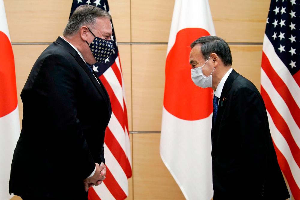 Japan’s Prime Minister Yoshihide Suga (R) and US Secretary of State Mike Pompeo greet prior to their meeting at the prime minister’s office in Tokyo on October 6, 2020. — AFP