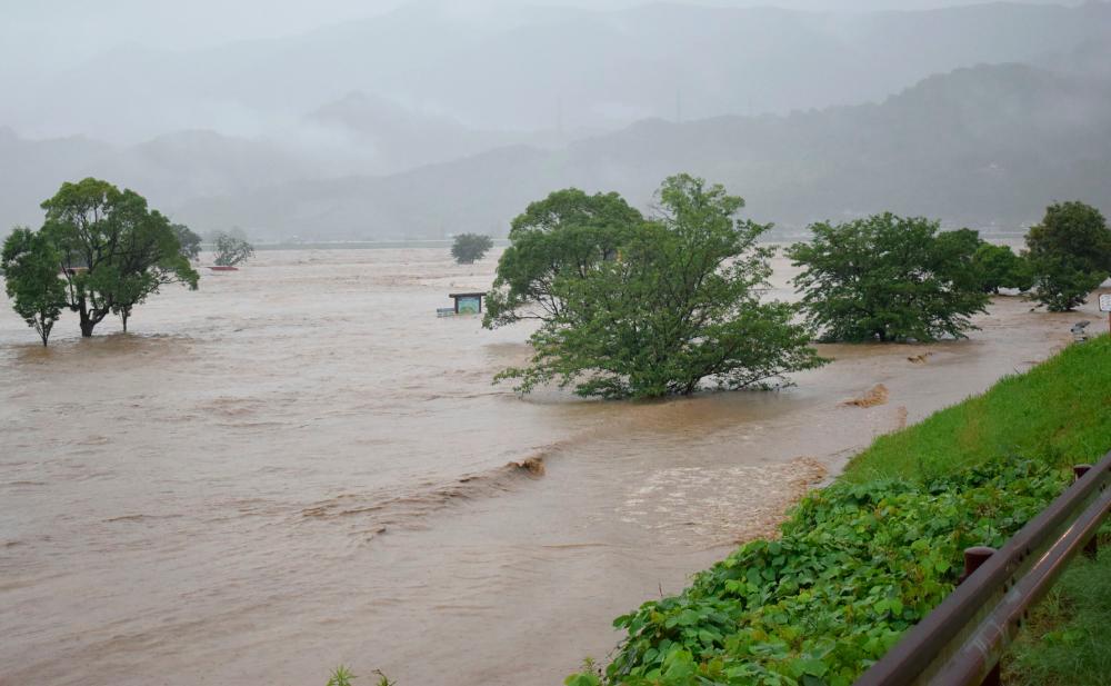Rising water caused by heavy rain is seen at Kuma river in Yatsushiro, Kumamoto prefecture on July 4, 2020. Some 75,000 people were ordered to evacuate in western Japan on July 4 as record heavy rain triggered floods and landslides, local media and officials said. The nation's weather agency issued the highest level of heavy rain warnings to Kumamoto and Kagoshima on Kyushu island. — AFP