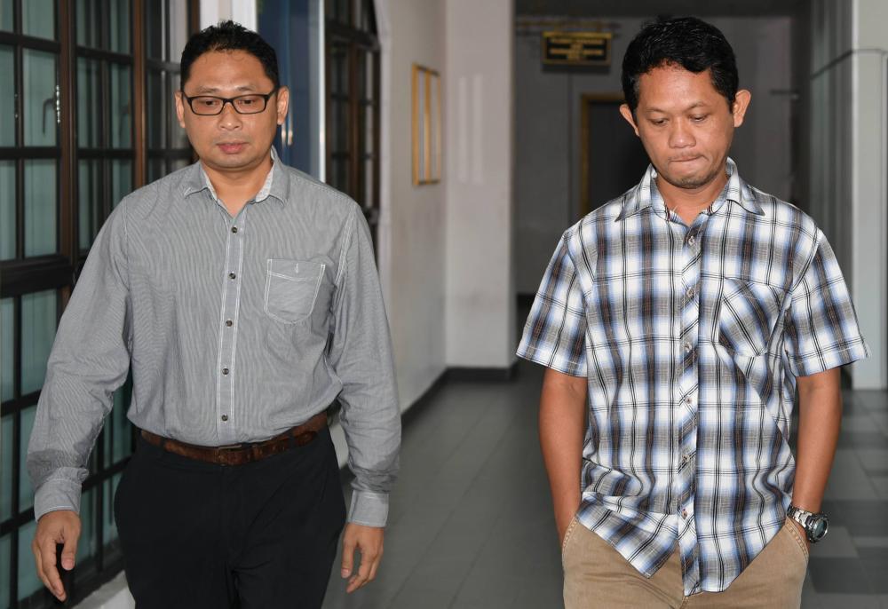 Sanizam Bachok, 45, (R) and Nor Yazid Khairi Mohamad Nor, 48, pleaded not guilty at the sessions court today to four counts of asking and receiving bribes from the ship’s owner four years ago. — AFP