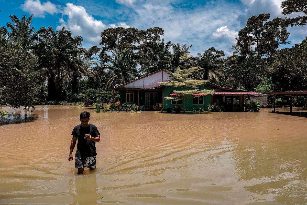 Seorang penduduk, Muhammad Riduan Jamil berjalan keluar dari rumahnya yang dinaiki air ketika tinjauan fotoBernama di Kampung Paya Embun, Pekan Nenas di sini hari ini -fotoBERNAMA