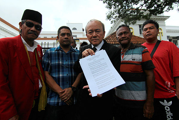 Lawyer Kamaruddin Ahmad (center) together with plaintiffs showing a list of defendants’ names in a summons at a press conference at Johor Baru High Court today.