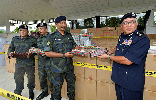Deputy Director of Internal Security and Public Order of the Royal Malaysia Police, Datuk Zainal Abidin Kasim (right) showing the confiscated goods at a press conference today. — Bernama