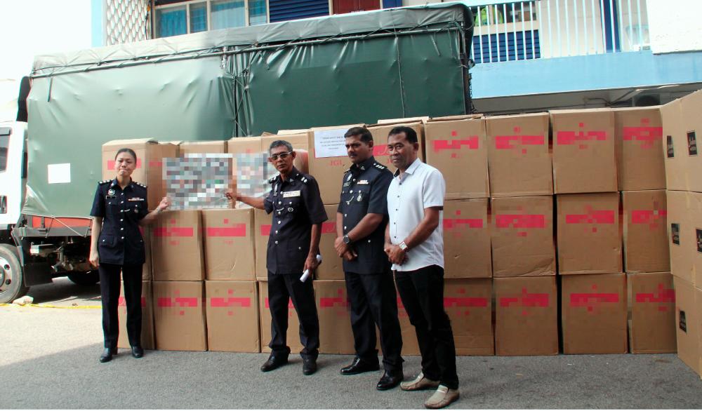 Tangkak District Police chief, Supt Mohad Idris Samsuri (2nd from L) shows off the seized cigarettes at a press conference at Tangkak police headquarters today. - Bernama