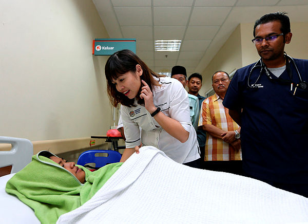 Deputy Education Minister Teo Nie Ching visits with a student who was affected by the chemical poisoning. — Bernama
