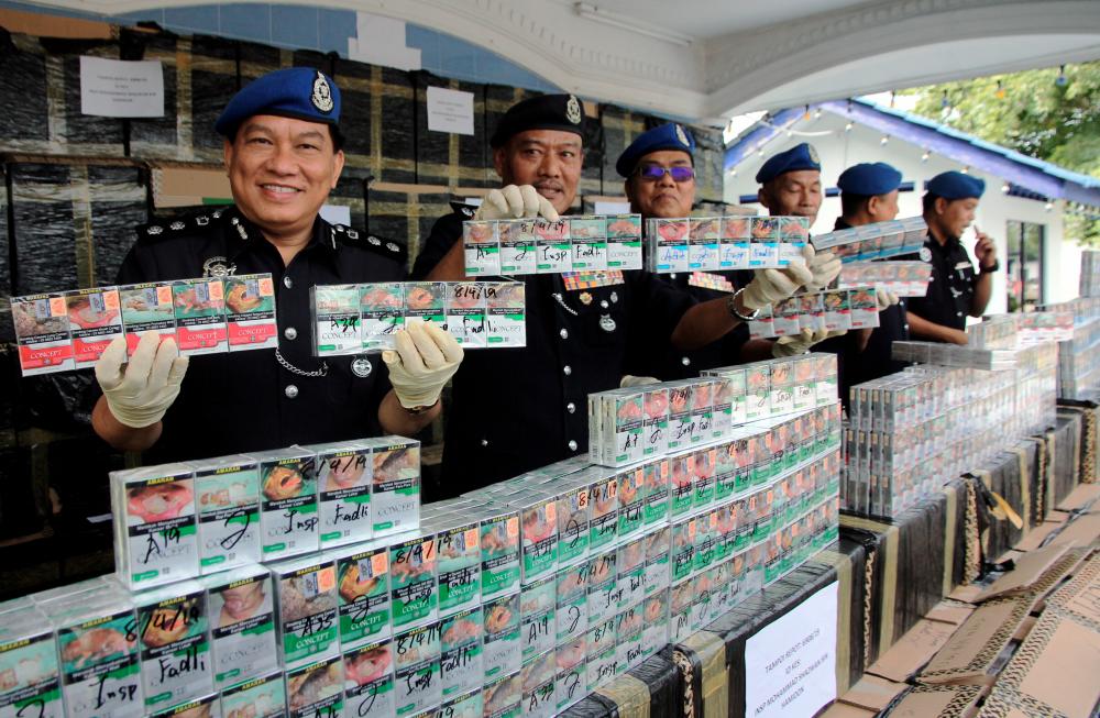 Regional Director of Marine Police (PPM) Commander 2 ACP Paul Khiu Khon Chiang (L) and Johor Baru North District Police Chief ACP Mohd Taib Ahmad (2L) shows some of the smuggled cigarettes seized at a press conference at the Region 2 Marine Police Team Headquarters , Tampoi, on April 9, 2019. — Bernama
