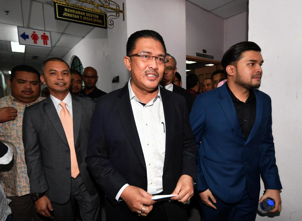 Former chairman of the Housing and Local Government Committee Datuk Abdul Latif Bandi (2R) with his son Ahmad Fauzan Hatim Abdul Latif (R) and real estate consultant Amir Sharifuddin Abd Raub (2L) released from the Johor Baru Sessions Court, April 21, 2019. — Bernama