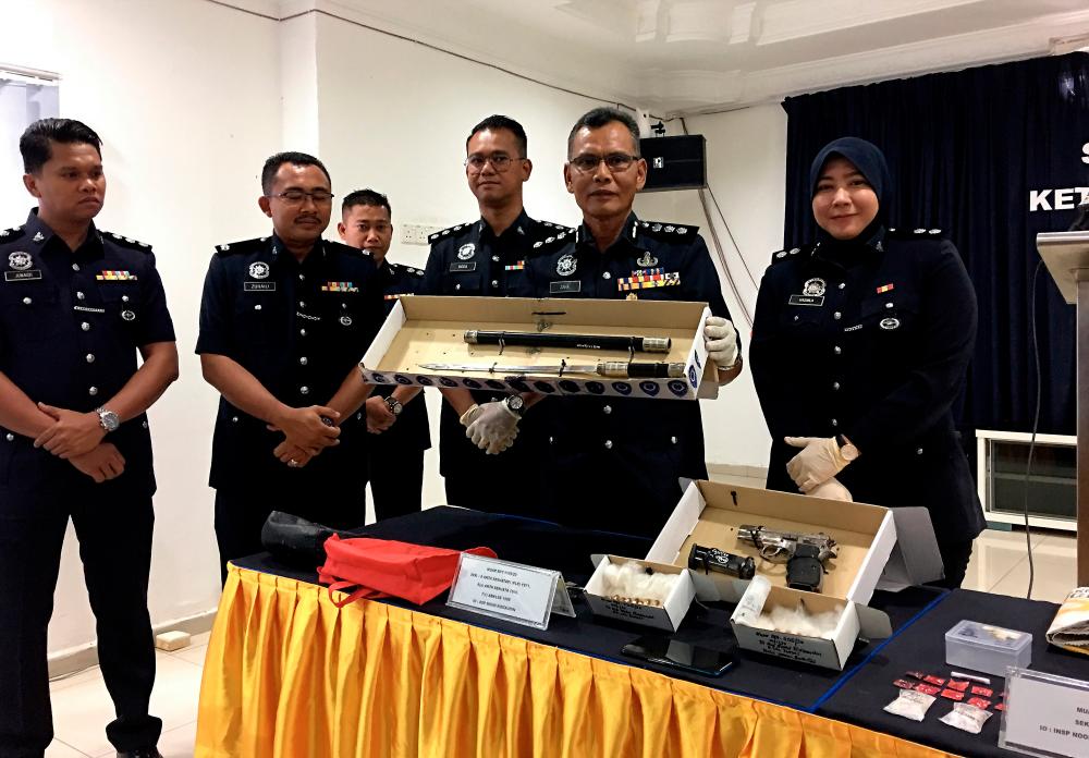 Muar district police chief ACP Zaharudin Rasip (2nd from R) shows a samurai sword that was seized during the detaining of a 25-year-old man at Jalan Bakri on Jan 25, during a press conference at the Muar District Police Headquarters today. - Bernama