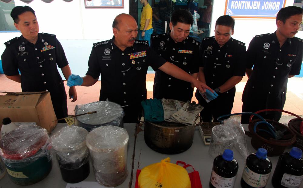 Johor police chief Datuk Mohd Kamarudin Md Din (2nd from L) and other police officers display the seized drugs and the laboratory equipment used to process the drugs at a press conference at Johor Baru police contingent headquarters today. - Bernama