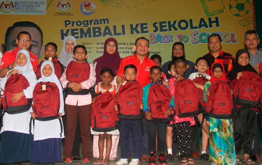 Education Minister Dr Maszlee Malik (back, right four) poses with some school bag recipients after launching the Back-to-school programme and the launch of Helogang public phone at Sekolah Menengah Kebangsaan Simpang Renggam today. - Bernama