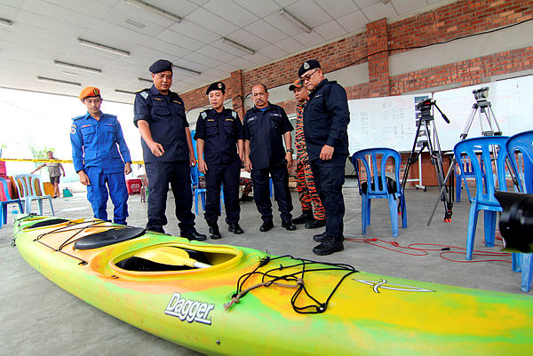 MMEA Mersing Zone director Maritime Commander Haris Fadzillah Abdullah (2nd from L) looks at a kayak found by a local fisherman during a press conference on a SAR operation of a Singapore man and woman, who were reported missing while kayaking in Endau waters near Mersing, last Thursday. — Bernama
