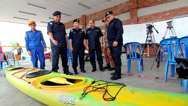 MMEA Mersing Zone director Maritime Commander Haris Fadzillah Abdullah (2nd from L) looks at a kayak found by a local fisherman during a press conference on a SAR operation of a Singapore man and woman, who were reported missing while kayaking in Endau waters near Mersing, last Thursday. — Bernama