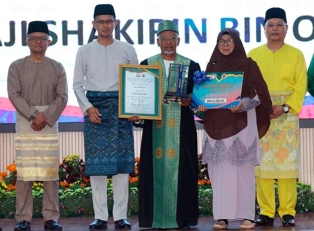 Pengerusi Jawatankuasa Hal Ehwal Agama Islam Negeri Johor Mohd Fared Mohd Khalid (dua, kiri) bergambar bersama penerima Anugerah Tokoh Maal Hijrah 1445H negeri Johor Shakirin Omar, 72, bersama isteri, Norlida Ismail, 72, pada Majlis Sambutan Maal Hijrah Peringkat Negeri Johor Tahun 1445H di Majlis Bandaraya Iskandar Puteri hari ini/BERNAMAPix