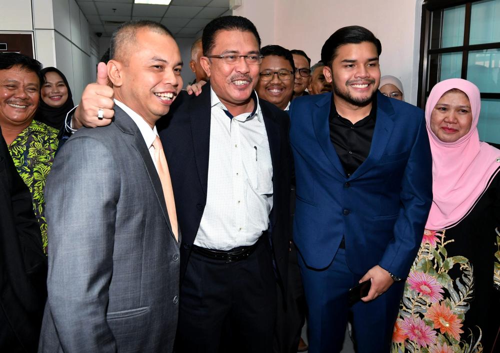Former chairman of the Housing and Local Government Committee Datuk Abdul Latif Bandi (2R) with his son Ahmad Fauzan Hatim Abdul Latif (R) and real estate consultant Amir Sharifuddin Abd Raub (2L) released from the Johor Baru Sessions Court, April 21, 2019. — Bernama