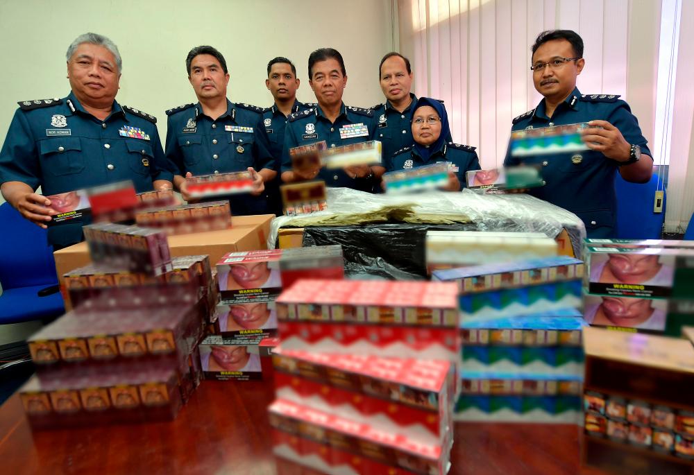 Johor Customs Department director Datuk Mohammad Hamiddan Maryani and other senior officers display the cigarettes seized on Dec 15 and Dec 23, at a press conference at the Sultan Abu Bakar Customs, Immigration and Quarantine (CIQ) Complex. - Bernama