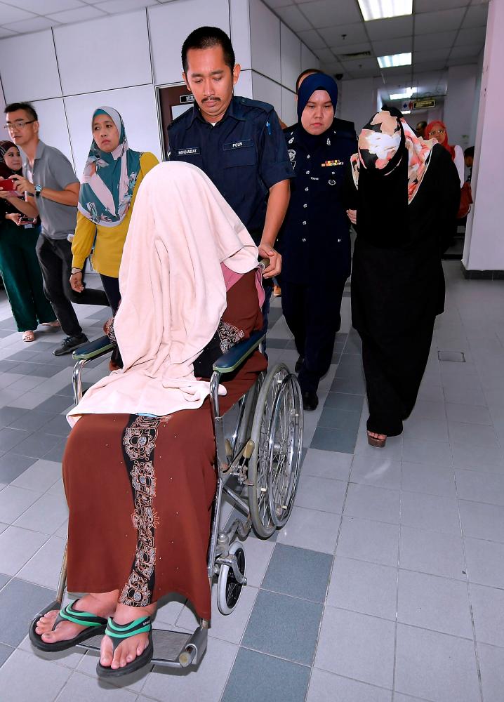 Ledang district health officer Dr Zaharah Mohda Salleh, 59, (front) and assistant accountant Noor Shazriena Miskam, 34, (R) were charged in the Johor Baru sessions court today on 49 charges of corruption. - Bernama