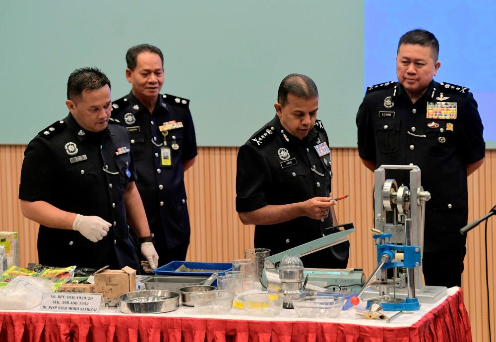 Johor police chief Datuk Ayob Khan Mydin Pitchay and his officers display various drugs including shabu, ketamine, ecstasy pills, eramin 5, pill printing machines, grinding machines and iron mills seized by police, at the Johor contingent police headquarters today. - Bernama