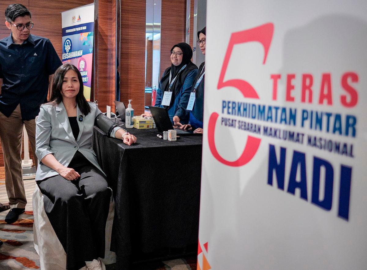 Timbalan Menteri Komunikasi Teo Nie Ching (tengah) melakukan pemeriksaan tekanan darah semasa melawat reruai pameran sempena perasmian Program Geran Digital PMKS MADANI (GDPM) Fest 2025 anjuran Suruhanjaya Komunikasi dan Multimedia (MCMC) hari ini-fotoBERNAMA