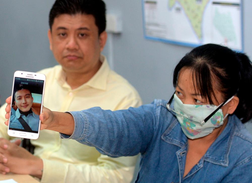 Stulang state assemblyman Andrew Chen Kah Eng (L) and Miss Lee, shows a picture of a foreigner involved in a ‘love scam’ syndicate during a press conference at the Stulang state assemblyman service centre today. - Bernama
